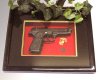 Pistol in shadow box w/glass cover